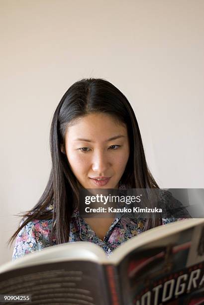 young woman is reading book - kazuko kimizuka stockfoto's en -beelden