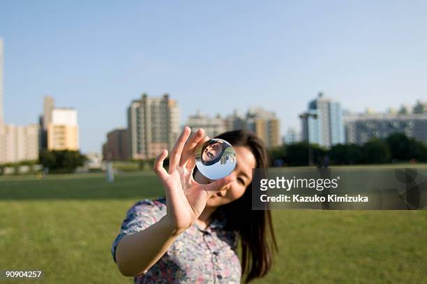young woman magnifying her face - kazuko kimizuka stockfoto's en -beelden