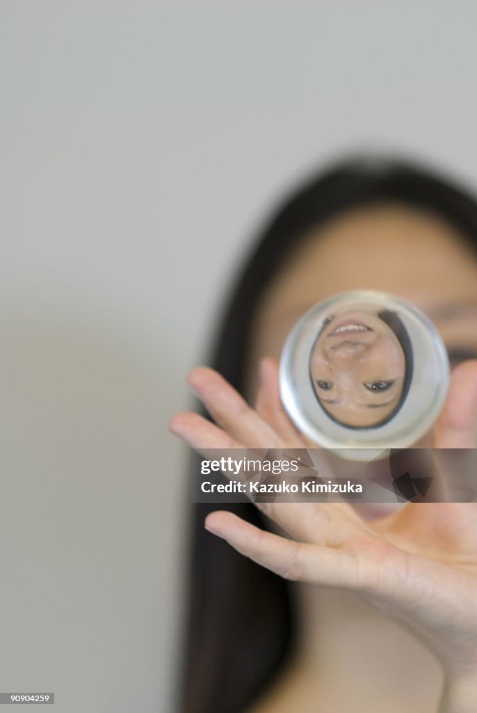 Young woman magnifying her face