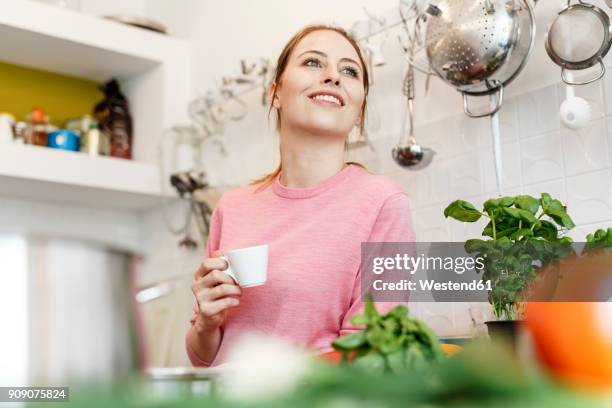 smiling young woman with cup of espresso in kitchen at home - espresso drink stock pictures, royalty-free photos & images