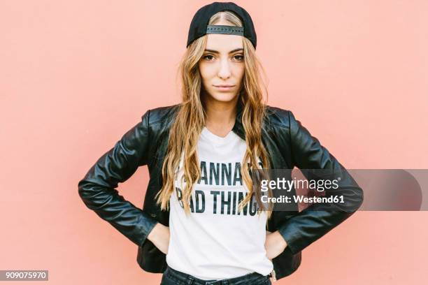 portrait of fashionable young woman wearing black baseball cap and leather jacket - baseball tee stock pictures, royalty-free photos & images
