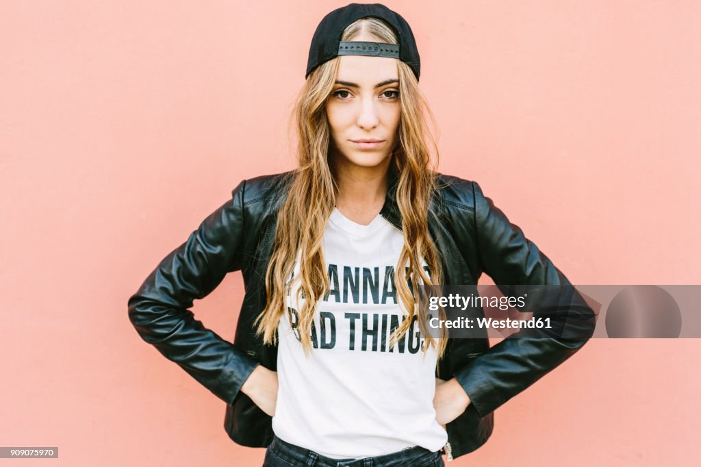 Portrait of fashionable young woman wearing black baseball cap and leather jacket