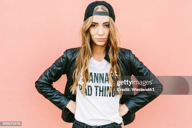 portrait of fashionable young woman wearing black baseball cap and leather jacket - unconventional imagens e fotografias de stock