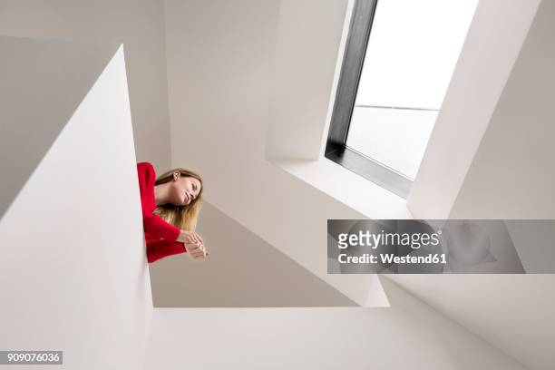 young woman on upper floor under roof window - blickwinkel der aufnahme stock-fotos und bilder