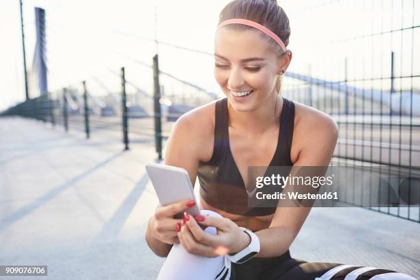 happy woman with smartphone after urban workout - happy people running stockfoto's en -beelden