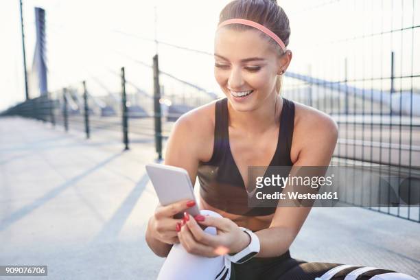 happy woman with smartphone after urban workout - checking sports stock pictures, royalty-free photos & images