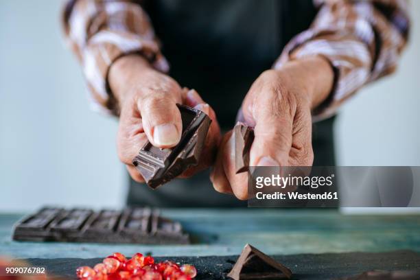 man's hands breaking a chocolate bar, close-up - choclate bar stock-fotos und bilder