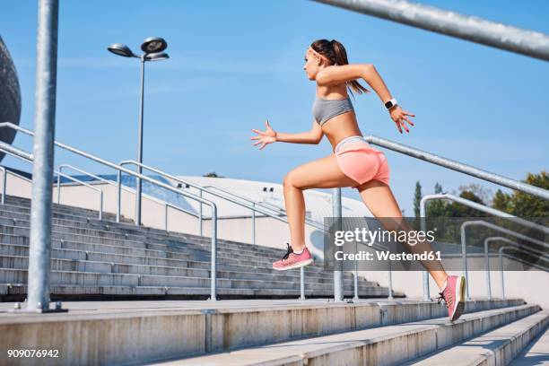 fit young woman running on stairs - computer indossabile foto e immagini stock
