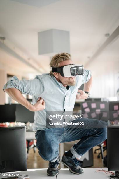businessman wearing vr glasses in office pretending to be a monkey - augmented reality animal stock-fotos und bilder