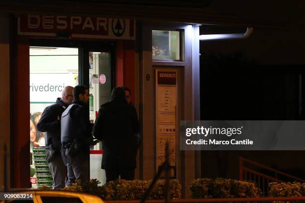 Police men guard the house from which a man, after killing his wife, started shooting people from the balcony.