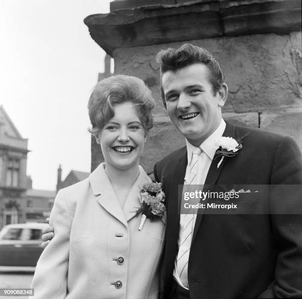 Liverpool goalkeeper Tommy Lawrence poses with his 19 year old bride Judith price after their wedding at Leigh Registry Office. 15th July 1963.
