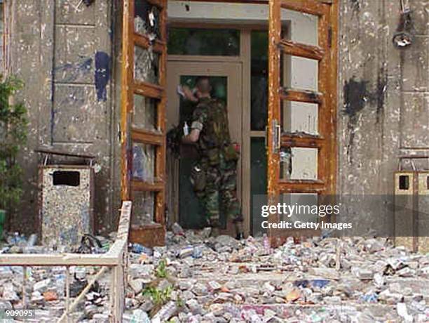 Marine Gunnery Sgt. Stephen Austin inspects damage caused to the U.S. Embassy building in Beijing May 10, following two days of attacks by Chinese...