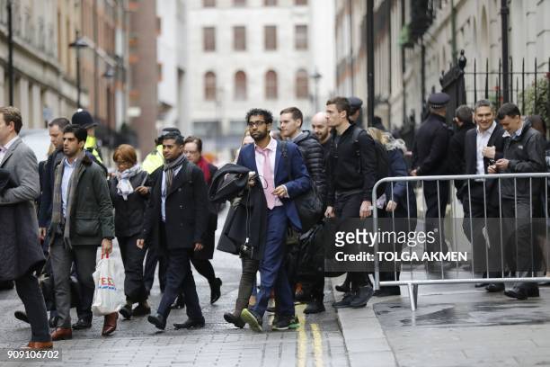 Workers are evacuated from offices on a street adjoining The Strand in central London on January 23, 2018 after a gas leak closed The Strand and...