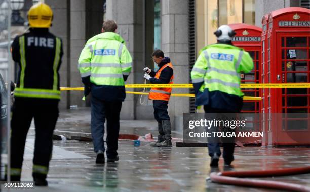 Emergency services and utilities personnel work at the scene of a gas leak on The Strand in central London on January 23, 2018. Almost 1,500 people...