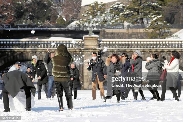 Foreign tourists make the most of the wintry surprise by making snowmen in front of Nijubashi bridge in the grounds of the Imperial Place on January...