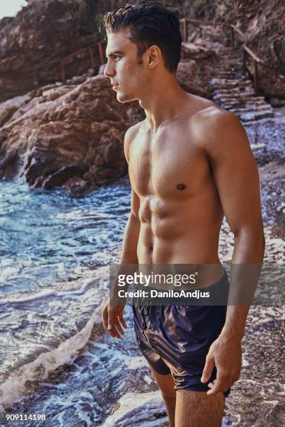 portrait of a handsome male model - hunky guy on beach stock pictures, royalty-free photos & images