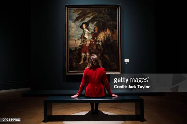 An employee poses in front of 'Charles I in the Hunting Field' by Anthony van Dyck during a press preview at the Royal Academy of Arts on January 23,...