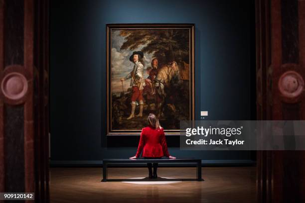 An employee poses in front of 'Charles I in the Hunting Field' by Anthony van Dyck during a press preview at the Royal Academy of Arts on January 23,...