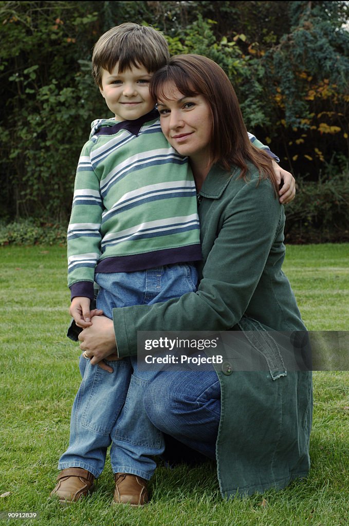 Boy and his loving mother outside in the garden