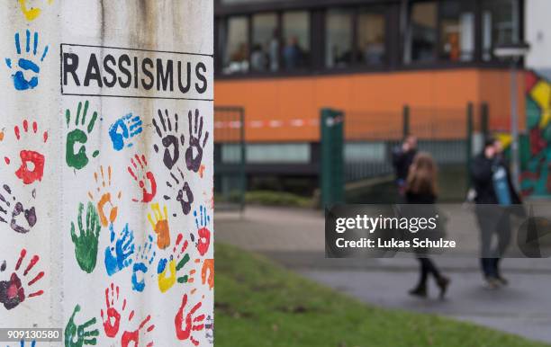 People leaves the Kaethe Kollwitz comprehensive school next to a pillar depicting "Racism" following the stabbing of a pupil on January 23, 2018 in...