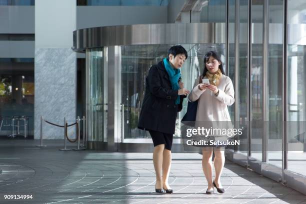 two asian businesswomen at the entrance - company town hall stock pictures, royalty-free photos & images