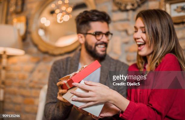 allegra giovane donna che riceve un regalo dal suo ragazzo. - regalo foto e immagini stock