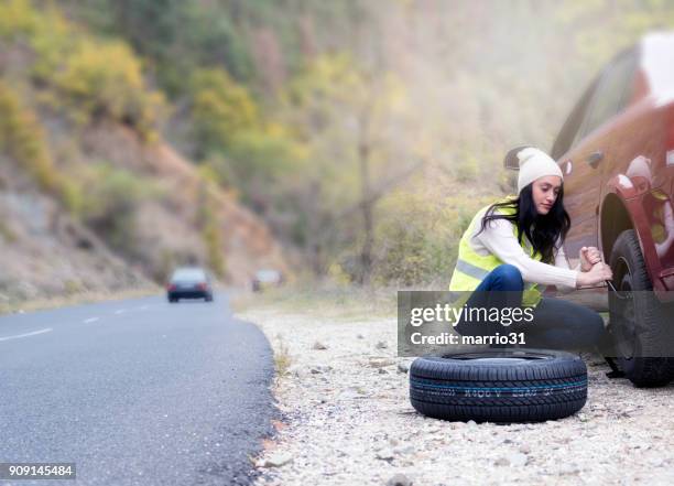 タイヤがパンクを変更する若い女性 - とらわれの姫 ストックフォトと画像