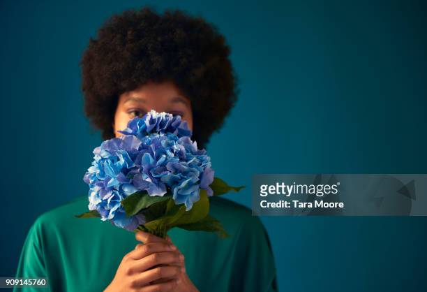 woman hiding behind flowers - shy stock pictures, royalty-free photos & images