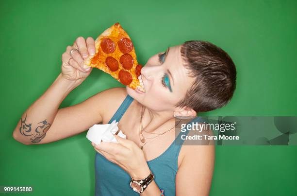 woman eating pizza slice - pizza fotografías e imágenes de stock
