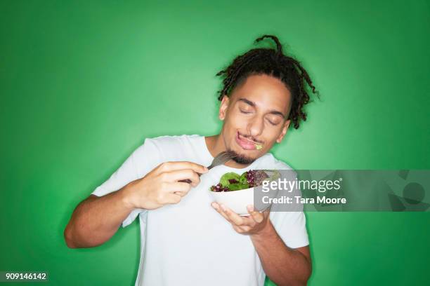 young hipster man eating salad - eating salad stockfoto's en -beelden