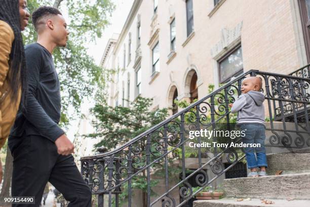 Young family with infant daughter in their city neighborhood stoop