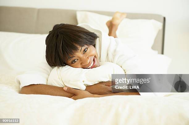 woman wearing bath robe, lying on bed - bath robe stockfoto's en -beelden
