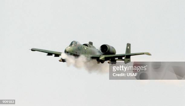 An air-to-air left front view of a 25th Tactical Fighter Squadron A-10 Thunderbolt II aircraft firing its 30mm gun at a target on the Koo-Ni range...