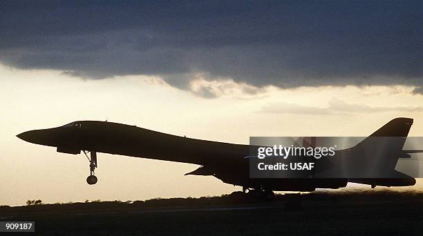 Bomber aircraft takes off on a night mission as the suns sets on the airfield.