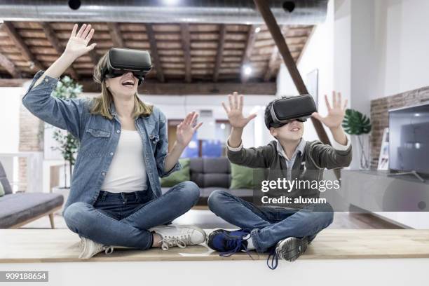 mother and son playing with virtual reality glasses in living room - 3d mom son stock pictures, royalty-free photos & images