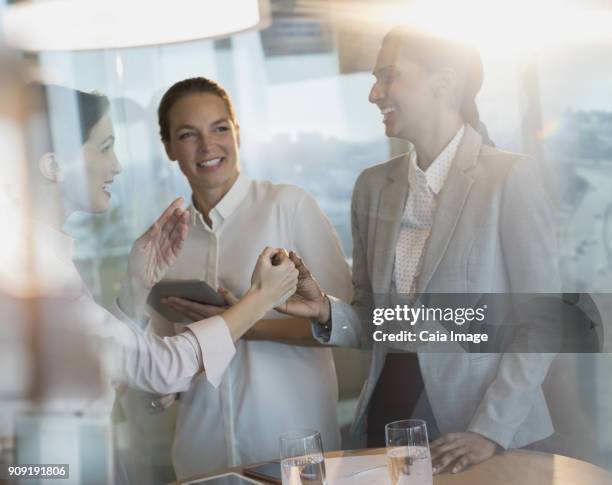 businesswomen laughing, handshaking in office meeting - first exposure series stock pictures, royalty-free photos & images