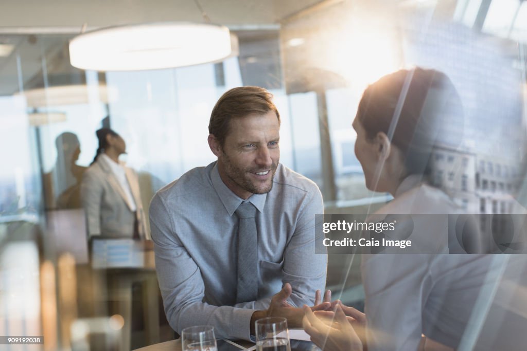 Businessman and businesswoman talking in office