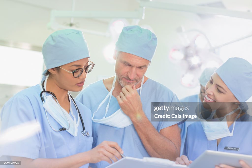 Surgeons reviewing paperwork in operating room