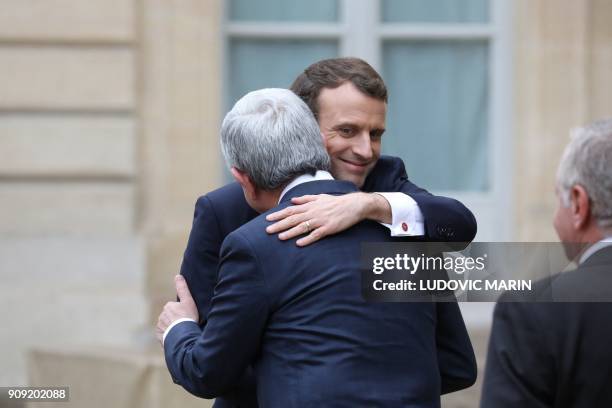 French president Emmanuel Macron hugs his Armenian counterpart Serzh Sarkisian as they walk out after a meeting at the Elysee palace in Paris on...