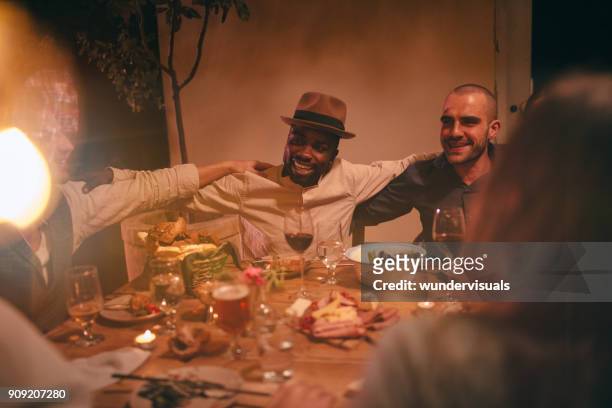 young multi-ethnic friends singing and celebrating at rustic dinner party - italy beer stock pictures, royalty-free photos & images