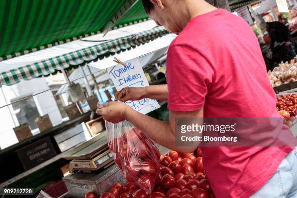 Customer selects tomatoes displayed for sale at an outdoor market in Sao Paulo, Brazil, on Thursday, Jan. 11, 2018. The Getulio Vargas Foundation is...