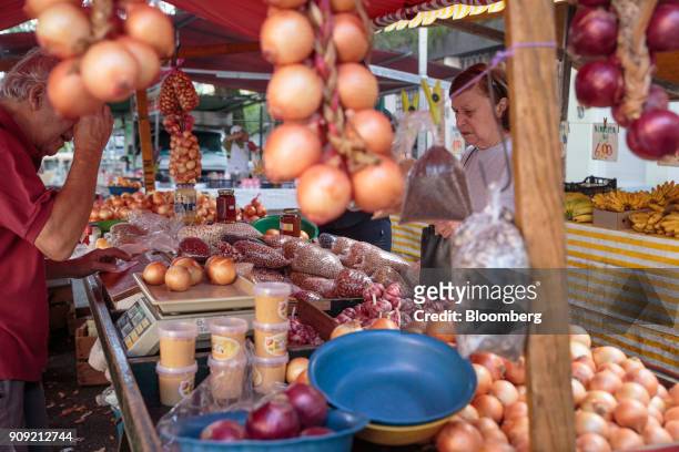 Vendor weighs fruit for a customer at a stall inside an outdoor market in Sao Paulo, Brazil, on Thursday, Jan. 11, 2018. The Getulio Vargas...
