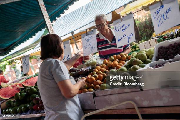 Vendor takes a bag of fruit to weigh for a customer at an outdoor market in Sao Paulo, Brazil, on Thursday, Jan. 11, 2018. The Getulio Vargas...