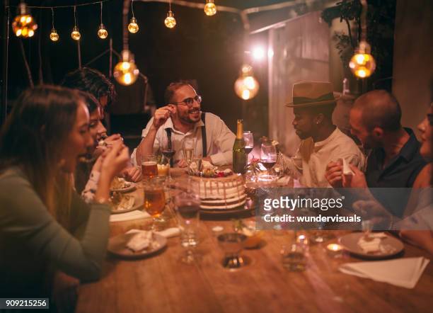 multi-ethnic friends eating gourmet birthday cake at rustic dinner party - evening meal restaurant stock pictures, royalty-free photos & images
