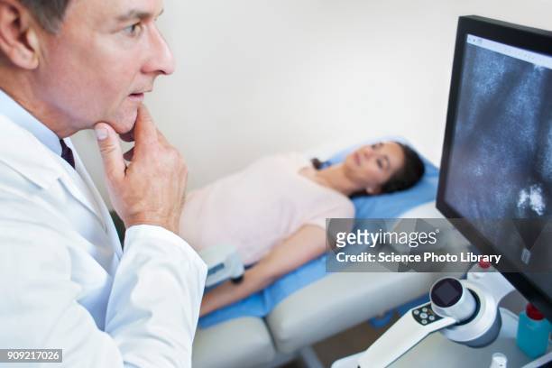 doctor looking at screen with hand on chin - stratum corneum imagens e fotografias de stock