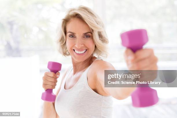 mature woman using hand weights - 僅成年女人 個照片及圖片檔