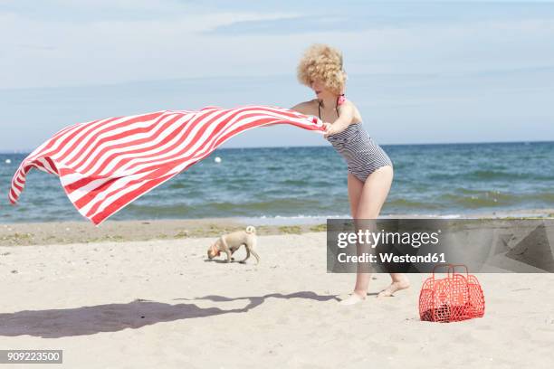 young woman with blowing beach towel at seaside - woman towel beach stockfoto's en -beelden