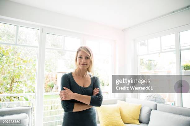 portrait of smiling woman at home - smiling controluce foto e immagini stock