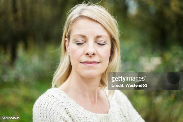 portrait of blond woman with eyes closed outdoors - woman portrait eyes closed stock pictures, royalty-free photos & images