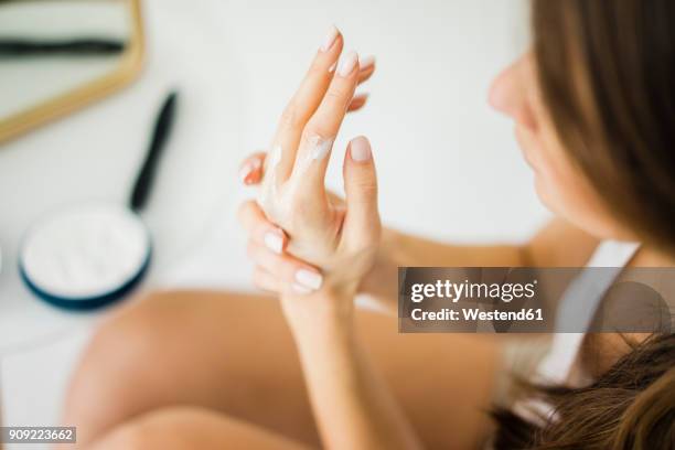 woman creaming her hands, partial view - hand cream stock pictures, royalty-free photos & images